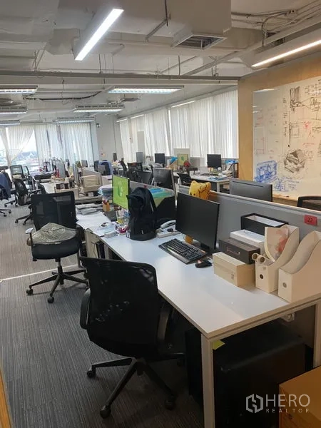 Office Space for rent in Khlong Toei, Bangkok - Open-plan office with rows of workstations, carpet tiles, and large windows with blinds in Khlong Toei.