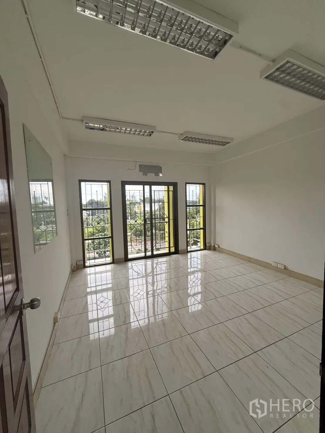 Shophouse for rent in Pak Kret, Nonthaburi - Sunlit room with large windows and balcony-style doors.