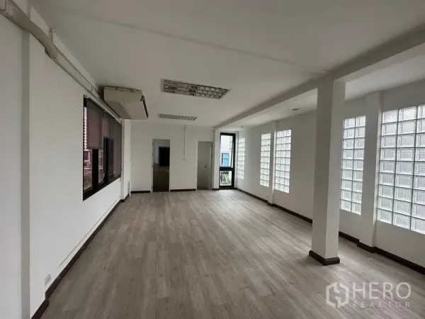 Office Space for rent in Sathon, Bangkok - Front section of 100 sqm office showing doorway to internal rooms, glass-block windows and abundant natural light.