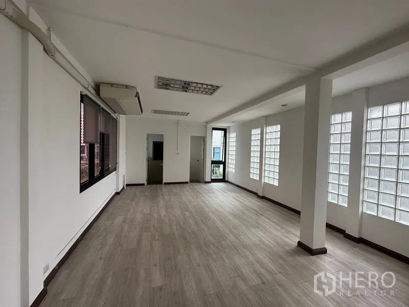 Office Space for rent in Sathon, Bangkok - Front section of 100 sqm office showing doorway to internal rooms, glass-block windows and abundant natural light.