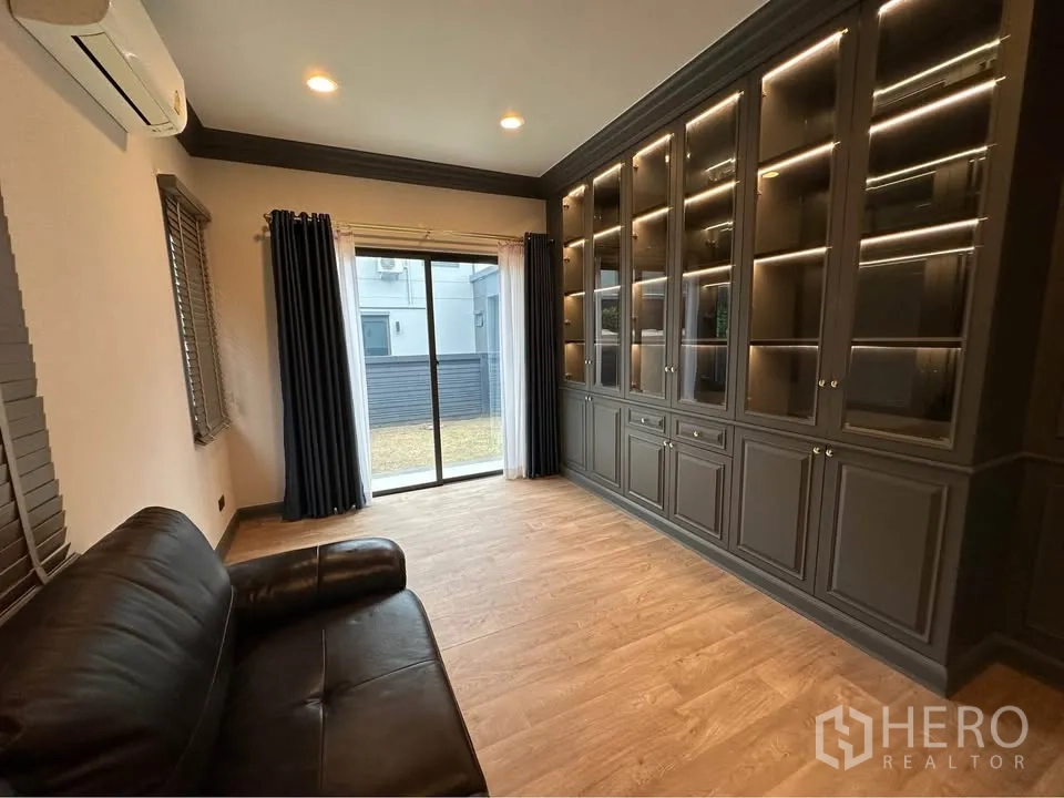 Detached House for rent in Bang Kapi, Bangkok - Same room showing sliding door to the garden and lit display cabinets.