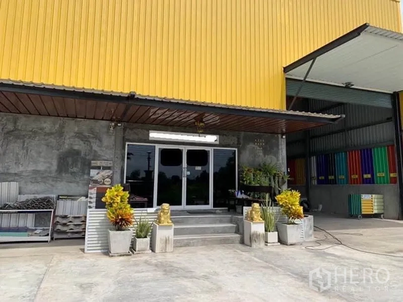 工厂 出售在Thanyaburi, Pathum Thani - 工厂正面，玻璃办公室入口、雨棚与绿植花盆。