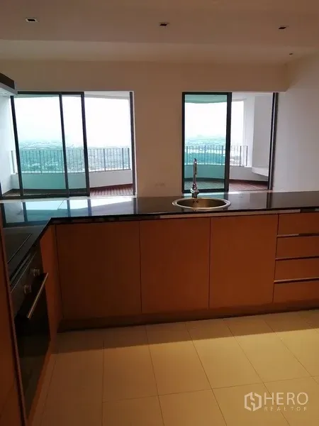 公寓 出售在Yan Nawa, Bangkok - 厨房中岛面向客厅与阳台，可见城市与河景。