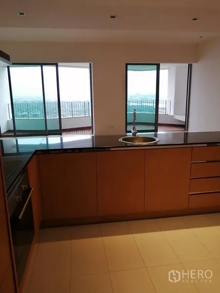 公寓 出售在Yan Nawa, Bangkok - 厨房中岛面向客厅与阳台，可见城市与河景。