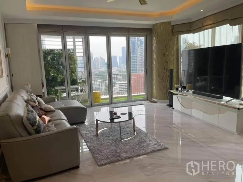 公寓 出售在Pathum Wan, Bangkok - 采光充足的客厅，石材地面，转角沙发，落地窗通向观景阳台与城市天际线。