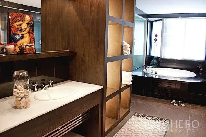 Condominium for rent in Yan Nawa, Bangkok - Spa‑style bathroom with wood cabinetry, open shelving and a corner jacuzzi bathtub by the window.