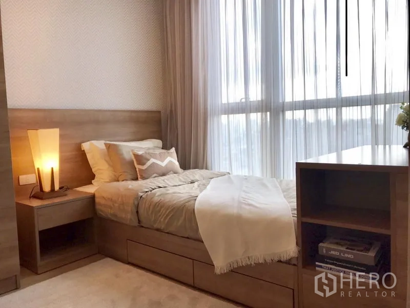 Condominium for rent in Khlong Toei, Bangkok - Cozy second bedroom with single bed, built-in storage and sheer drapes at a wide window.