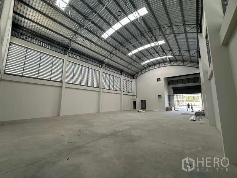 工厂 出售在Lam Luk Ka, Pathum Thani - 宽阔仓库，混凝土地面，高屋顶，两侧百叶通风。