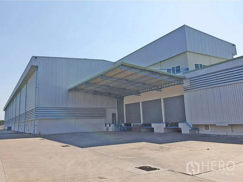 货栈 出租在Lat Krabang, Bangkok - 立面展示多道卷闸装卸口，雨棚覆盖，院内空间充裕便于卡车调头。