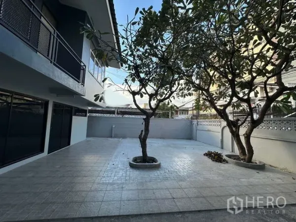 Home Office for rent in Din Daeng, Bangkok - Spacious tiled courtyard with two mature trees beside a two-storey home office in Din Daeng.