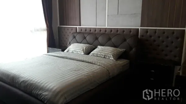 公寓 出租或出售在Watthana, Bangkok - 主卧配软包床头与条纹床品，采光良好并设遮光窗帘。