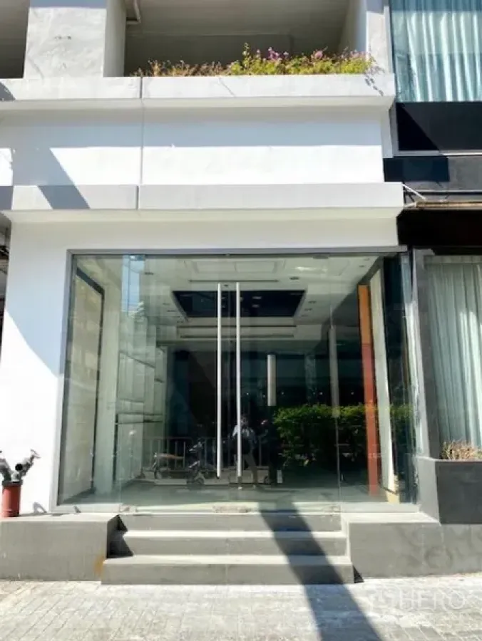 Retail Space for rent in Pathum Wan, Bangkok - Ground-floor retail entrance with full-height glass facade, double glass doors, steps, and a modern white exterior.
