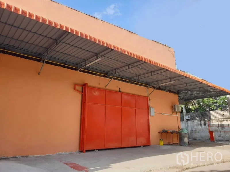 คลังสินค้า ให้เช่าในDin Daeng, Bangkok - ด้านหน้าโกดังสีส้ม ประตูเหล็กบานเลื่อนขนาดใหญ่ พร้อมกันสาดลานขนถ่ายสินค้า ย่านดินแดง