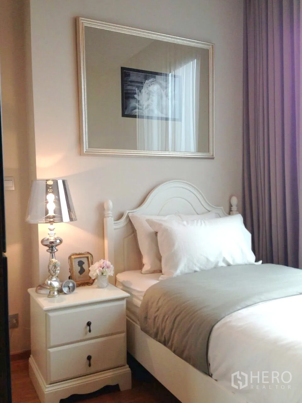 Condominium for rent in Khlong Toei, Bangkok - Bright second bedroom with single bed, bedside table, lamp and full-length drapes.