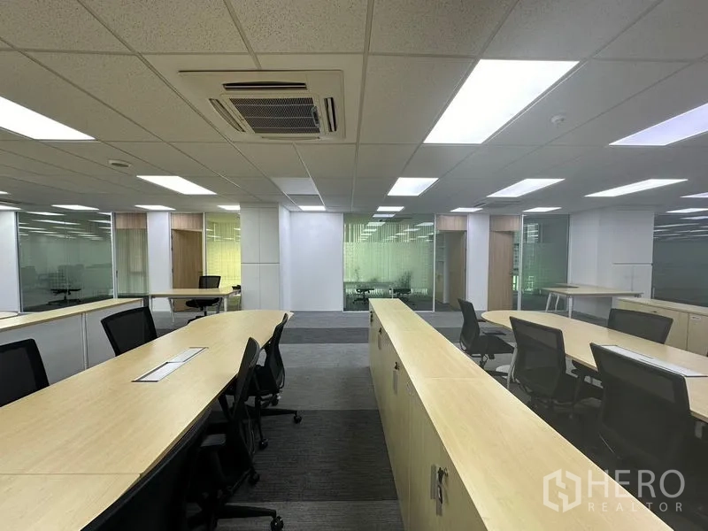 สำนักงาน ให้เช่า - โซนทำงานร่วมกัน มีฉากกั้นไม้โทนอ่อน เก้าอี้ทำงาน และห้องผนังกระจก