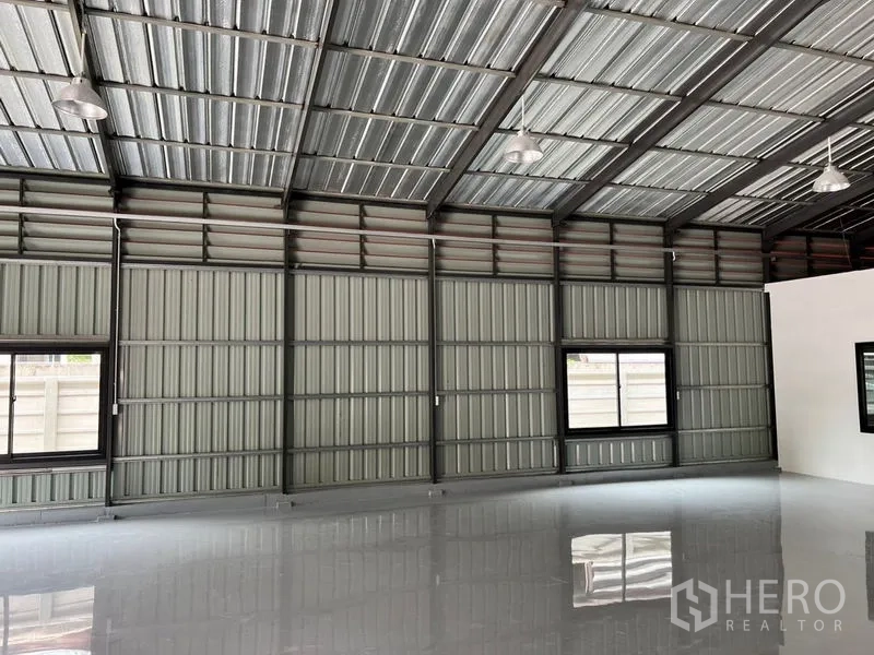Warehouse for rent in Lat Phrao, Bangkok - Side wall of the warehouse with ventilation louvers, windows and hanging high-bay lights.