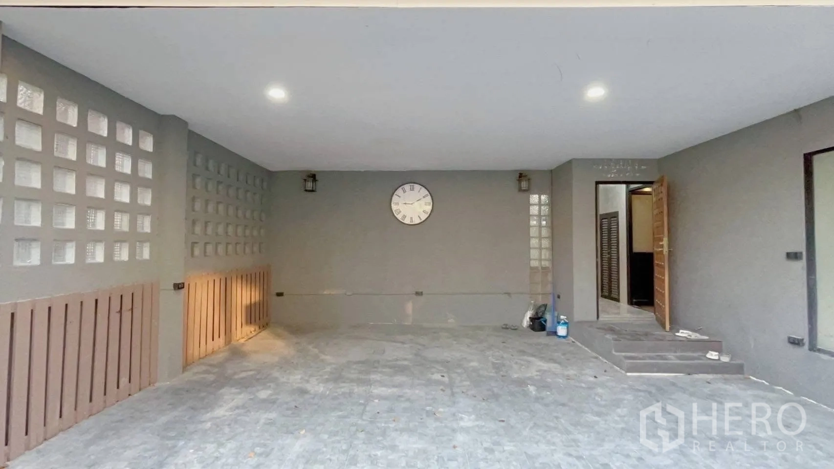 Detached House for rent or sale in Wang Thonglang, Bangkok - Covered carport with wall clock, glass-block ventilation and entry steps beside the front door.