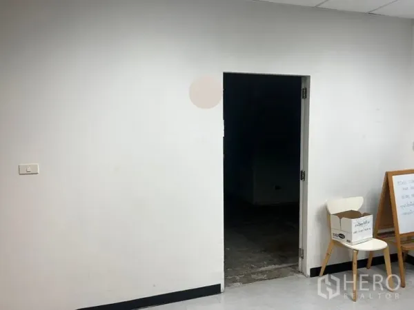 办公空间 出租 - 简洁的入口区，白色墙面与通往未完工办公室的门洞。