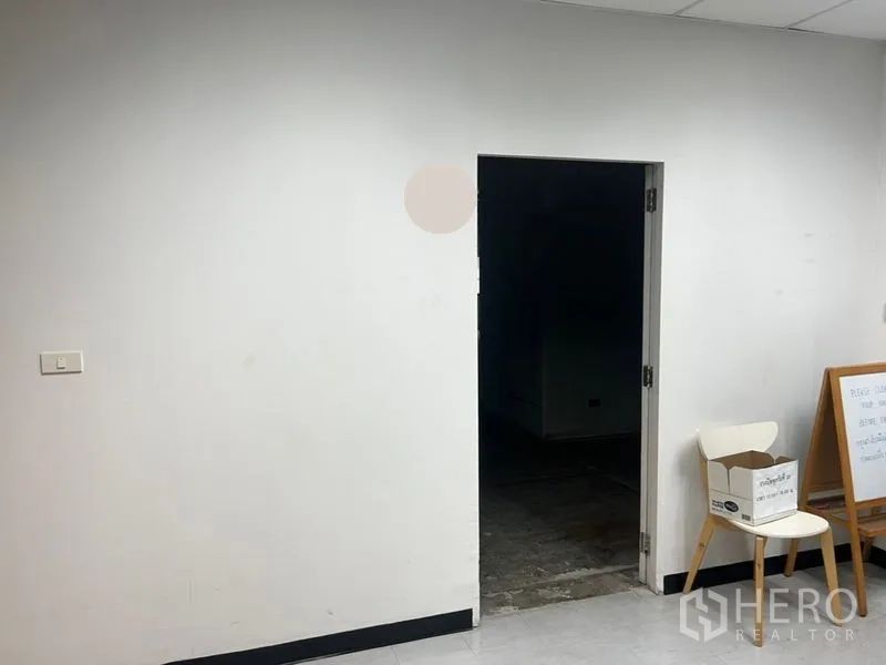 办公空间 出租 - 简洁的入口区，白色墙面与通往未完工办公室的门洞。