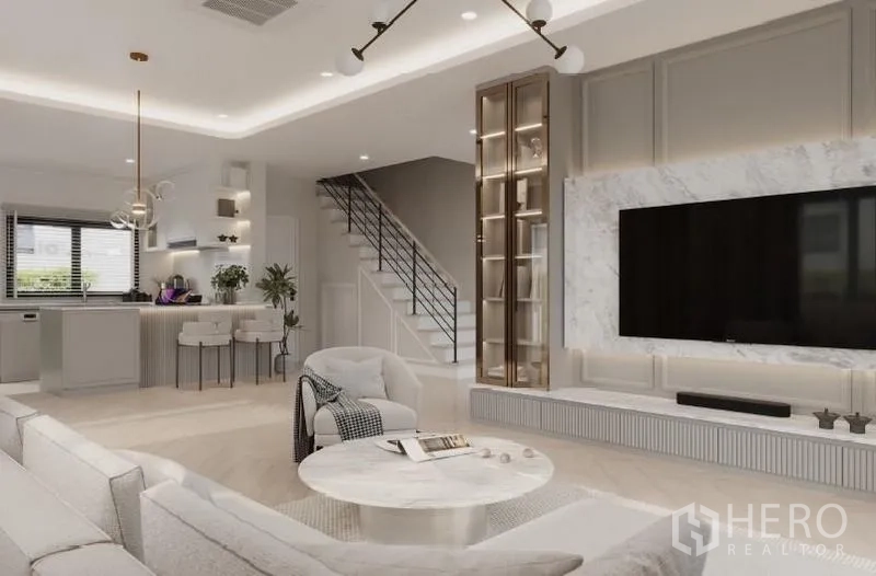 Detached House for rent in Bang Phli, Samut Prakan - Open-plan family area showing kitchen peninsula, staircase and marble media wall.