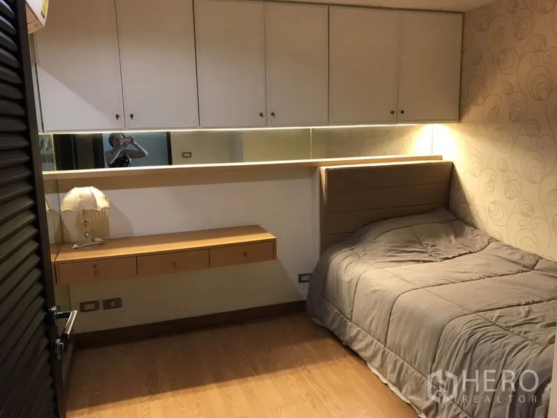 公寓 出租在Watthana, Bangkok - 温馨次卧，内置衣柜、长镜与悬空书桌，单人床与暖色灯光。