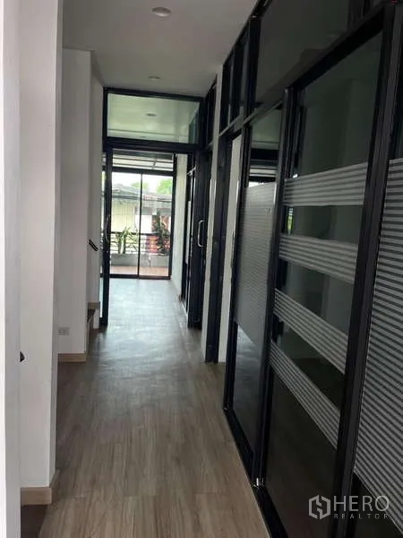 带办公室的家 出租或出售在Wang Thonglang, Bangkok - 走廊两侧为玻璃隔断办公室，尽头通向阳台