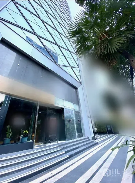 พื้นที่ขายปลีก ให้เช่าในWatthana, Bangkok - มุมมองภายนอกของฐานอาคารสูง มีทางเดินลายเส้นและต้นปาล์ม