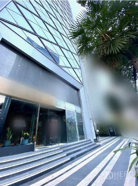 พื้นที่ขายปลีก ให้เช่าในWatthana, Bangkok - มุมมองภายนอกของฐานอาคารสูง มีทางเดินลายเส้นและต้นปาล์ม