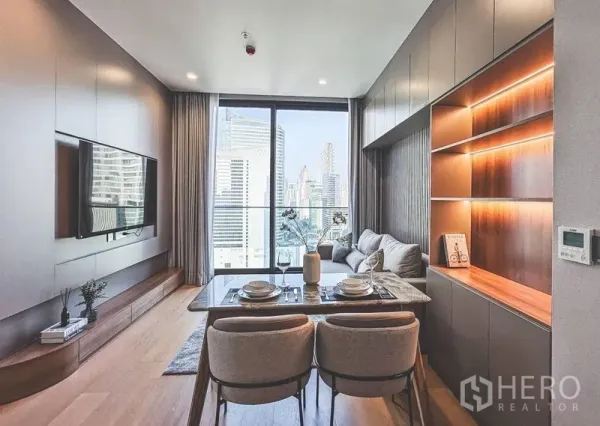 公寓 出租在Bang Rak, Bangkok - 开放式起居区，餐桌与到顶玻璃，框取城市景色。