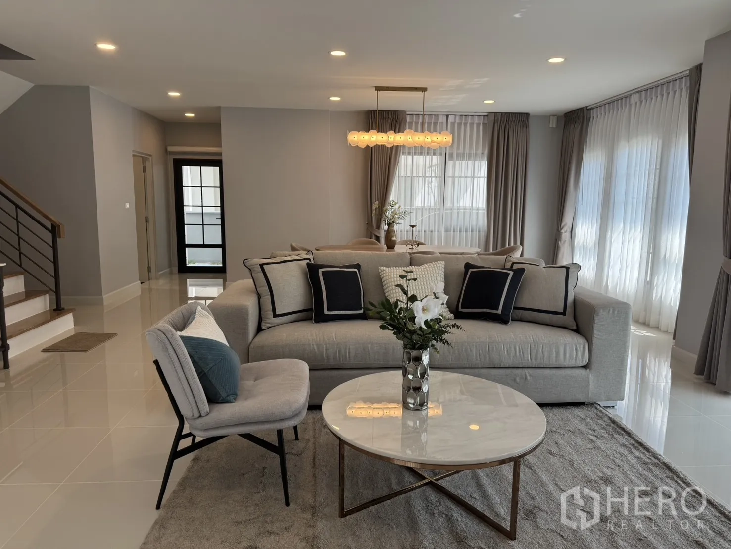 บ้าน for rent in Bang Phli, Samut Prakan - ห้องนั่งเล่นโซฟาสีเทา โต๊ะกลางหินอ่อนทรงกลม มองเห็นบันไดและส่วนรับประทานอาหาร