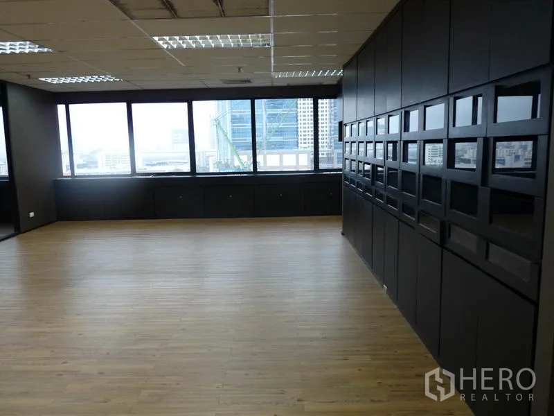Office Space for rent in Watthana, Bangkok - Bright office with wide windows, black storage cabinets and a feature wall of framed openings.