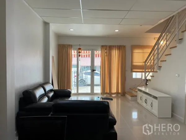 联排别墅 出租在Wang Thonglang, Bangkok - 开放式客厅，落地窗帘与通往二层的楼梯