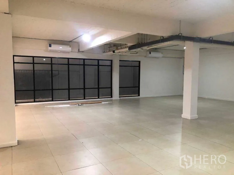 Office Space for rent in Phaya Thai, Bangkok - Large empty office room with black-framed windows and tiled flooring.