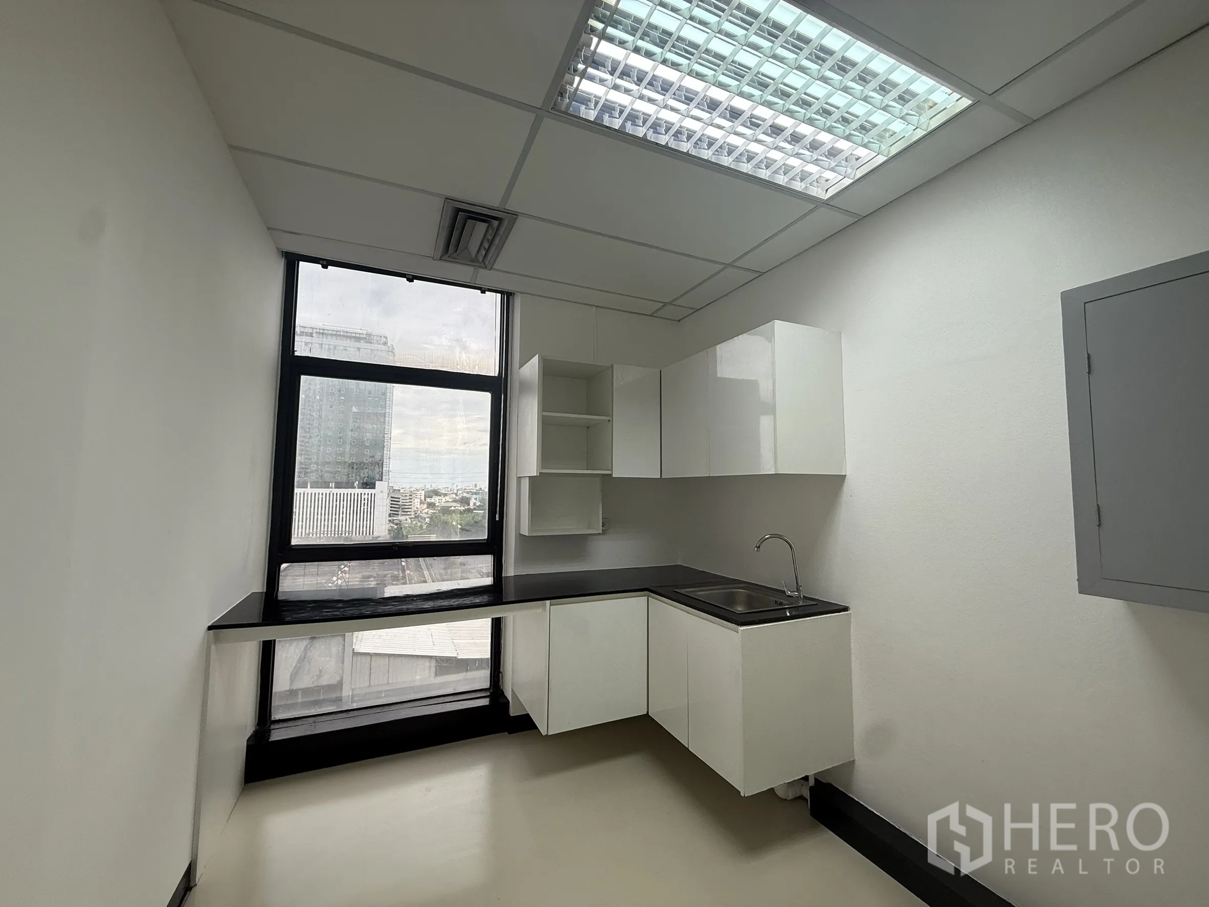 สำนักงาน ให้เช่า - แพนทรีขนาดกะทัดรัด ตู้บิลท์อินสีขาว ซิงก์ล้างจาน และหน้าต่างสูงมองเห็นเมือง