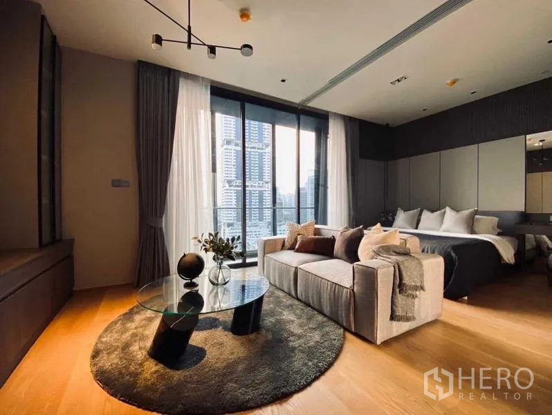 Condominium for rent or sale - Cozy seating area by large windows beside the bedroom, city skyline beyond.
