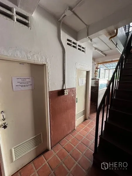 Retail Space for rent or sale in Khlong Toei, Bangkok - Stairwell and service corridor with tiled floor and access doors.