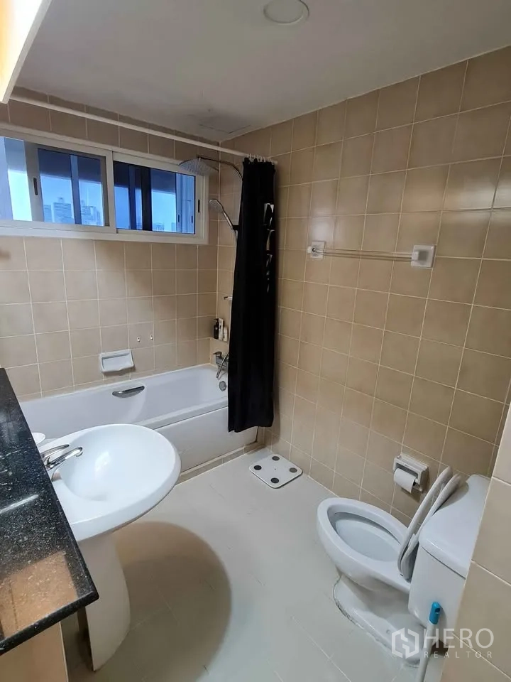 คอนโด for rent in Khlong Toei, Bangkok - ห้องน้ำปูกระเบื้องพร้อมอ่างอาบน้ำ ม่านกั้น อ่างล้างหน้า และโถสุขภัณฑ์.