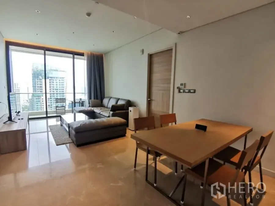 Condominium for rent in Pathum Wan, Bangkok - Alternate angle of the living and dining area opening to a balcony with skyline views.
