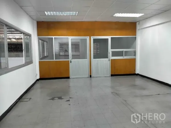 Warehouse for rent in Bang Phli, Samut Prakan - First-floor office area with glass partitions and fluorescent ceiling lights.