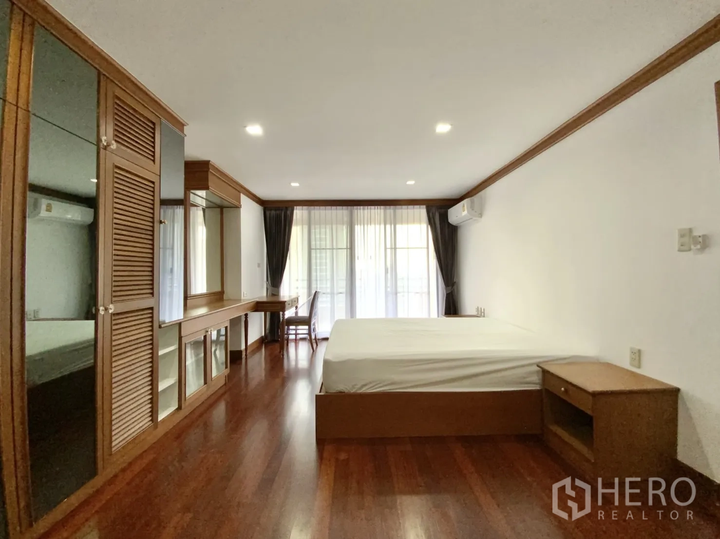 公寓 出租在Watthana, Bangkok - 卧室连接阳台，内置衣柜与书桌，木地板。