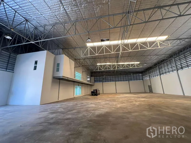 Warehouse for rent in Prawet, Bangkok - High-clearance storage hall with steel trusses and polished concrete floor.