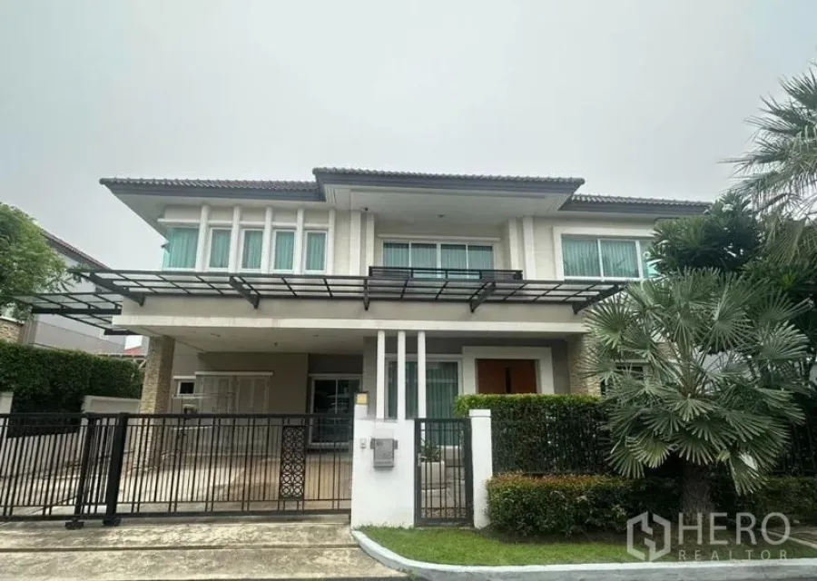 独立式住宅 出售在Saphan Sung, Bangkok - 现代两层住宅正立面，金属大门与车棚。