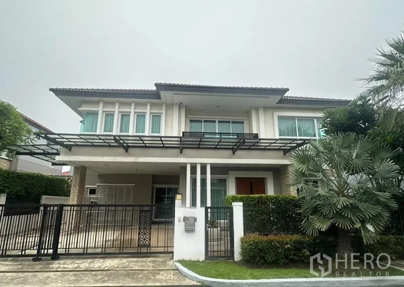 独立式住宅 出售在Saphan Sung, Bangkok - 现代两层住宅正立面，金属大门与车棚。
