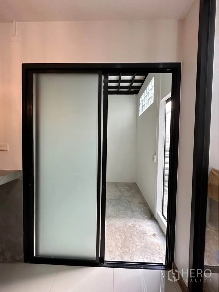 联排别墅 出租在Pak Kret, Nonthaburi - 磨砂推拉门，通向带玻璃砖的紧凑储物区。