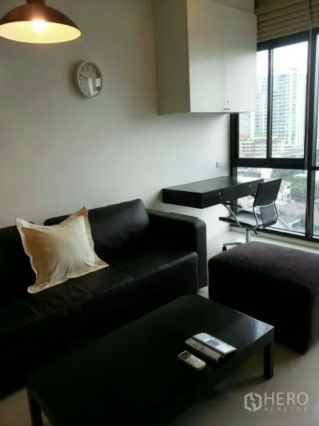 คอนโด ให้เช่าในPhaya Thai, Bangkok - ห้องนั่งเล่นสไตล์โมเดิร์น โซฟาหนัง โต๊ะกลาง และหน้าต่างบานใหญ่รับวิวเมือง