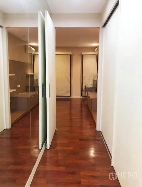 Townhouse for rent in Wang Thonglang, Bangkok - Upper-floor hallway with mirrored sliding doors and polished wood floors.