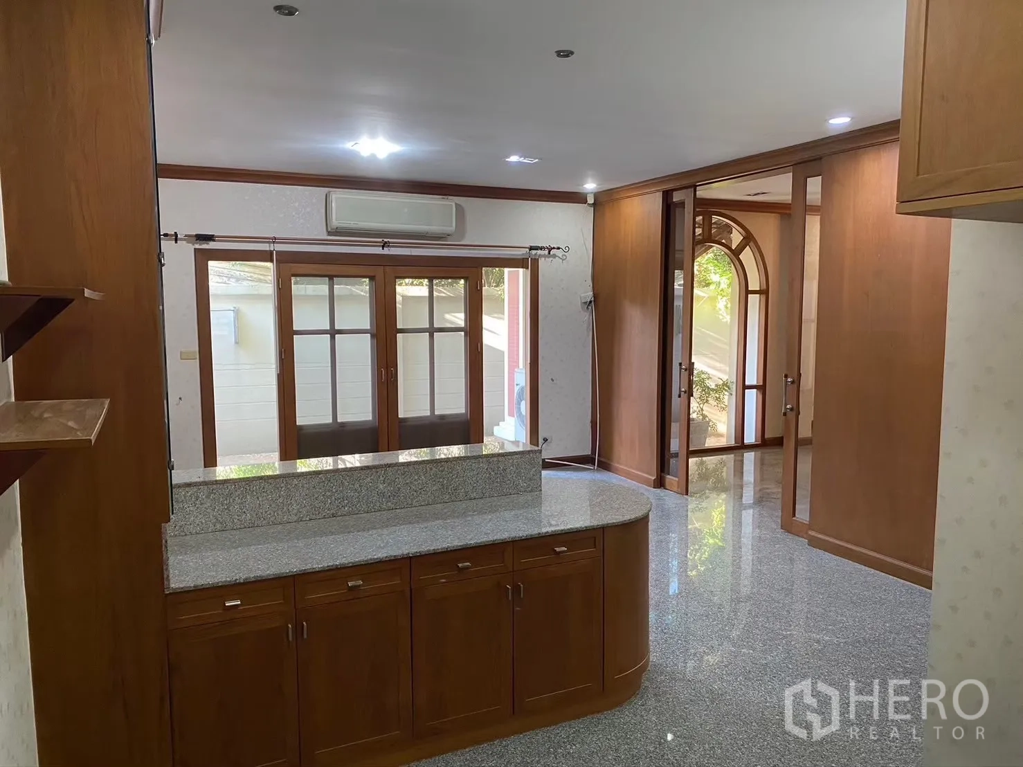 Detached House for rent in Watthana, Bangkok - Kitchen lounge with granite counter and doors opening to the yard.