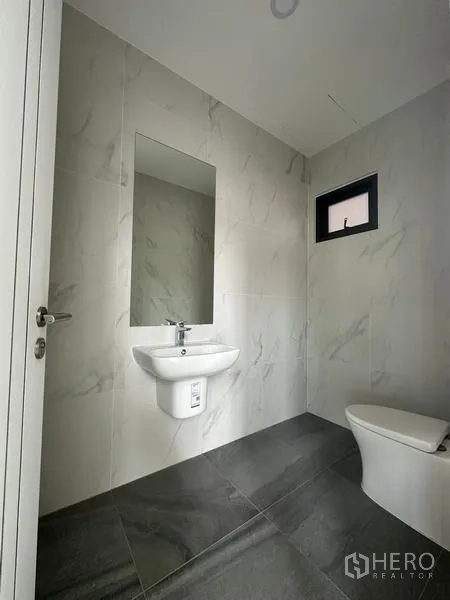 Warehouse for sale in Lam Luk Ka, Pathum Thani - Modern restroom with marble-look tiles, wall-mounted sink and toilet.