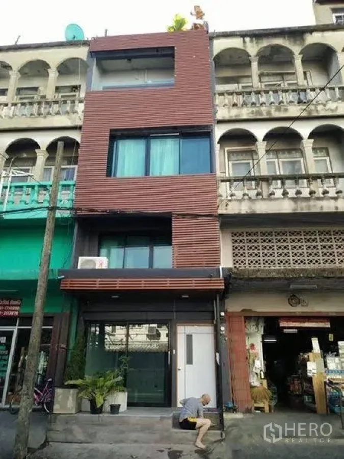 Shophouse for sale in Phra Khanong, Bangkok - Contemporary multi-storey shophouse facade with glass storefront and wood slat panels.