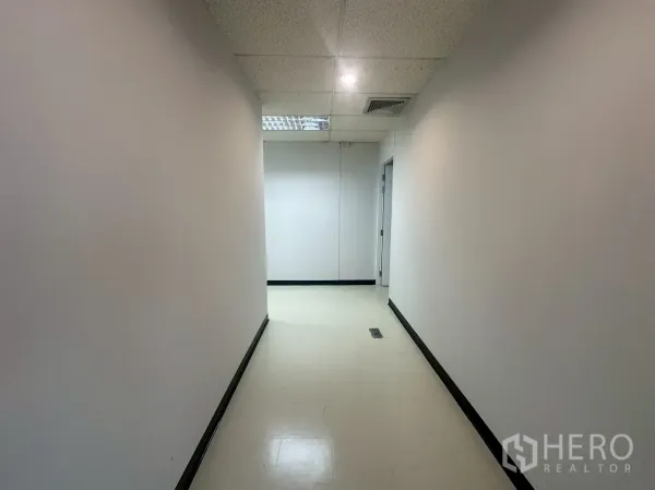 办公空间 出租 - 干净的内部走廊，白色墙面与嵌灯，通往各办公房间。